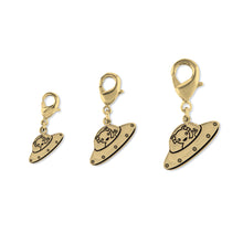 Cargar imagen en la Galería, Colgante con mosquetón a modo de charm, con el dibujo de un platillo volante y un marciano. Material: latón chapado oro 18k. Tres medidas. Para colgar de pulseras, cremalleras o mochilas.